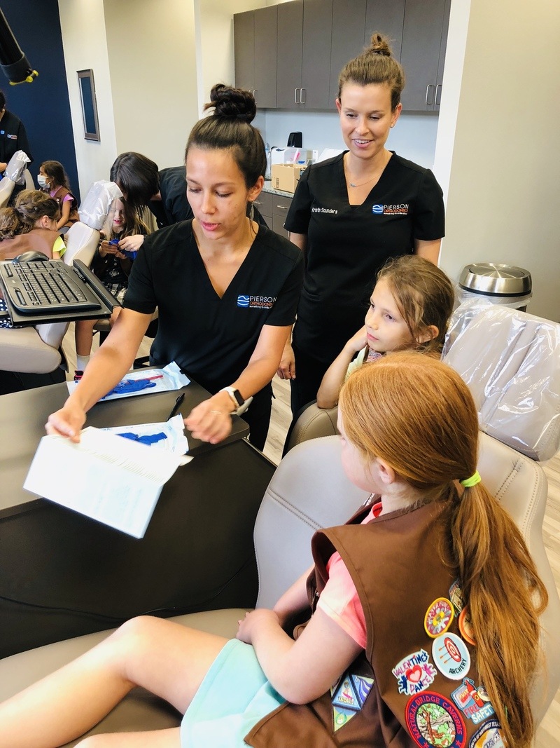 Girl Scouts being educated by a dental assistant